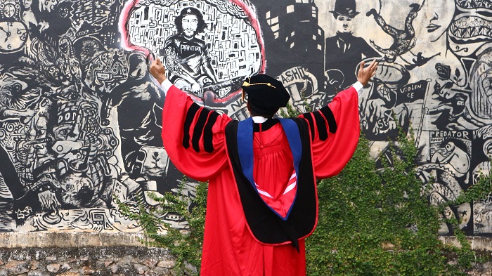 Saiful Mahdi in front of a mural outside the offices of LBH Aceh / Saiful Mahdi